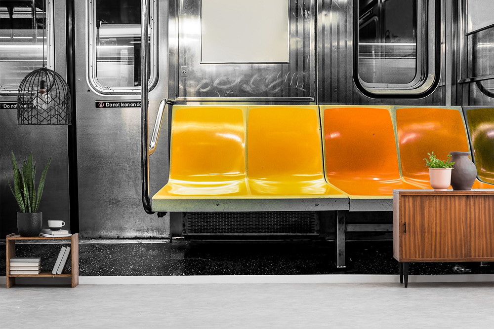 Fotobehang - Moderne woonkamerdecoratie met een afbeelding van een rij metrobankjes in geel en oranje, omringd door kamerplanten en meubels.