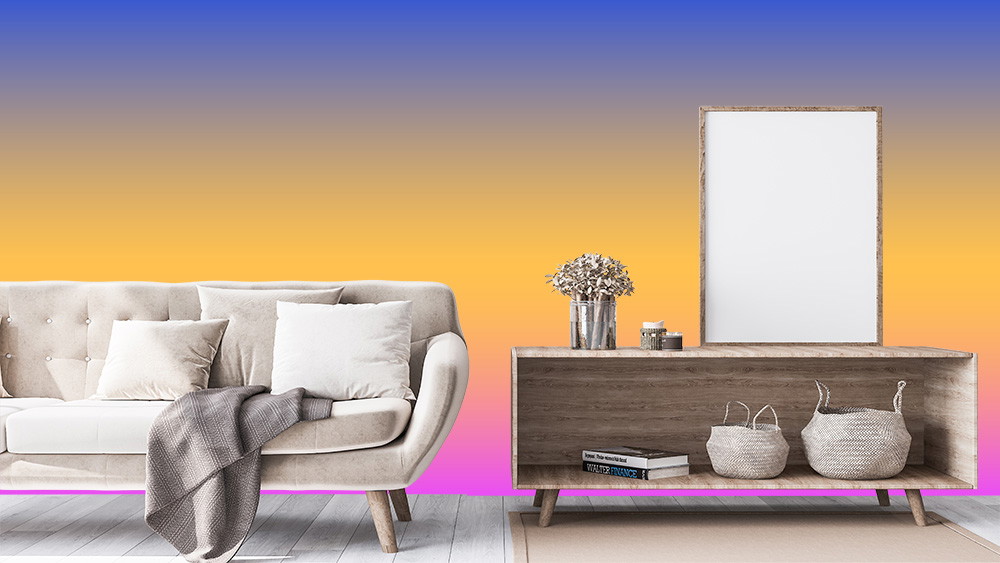 Fototapete - Elegant eingerichtetes Wohnzimmer mit einem beigen Sofa, Kissen und Decke, sowie einem hölzernen Sideboard mit Dekoelementen vor einem farbenfrohen Verlaufshintergrund.