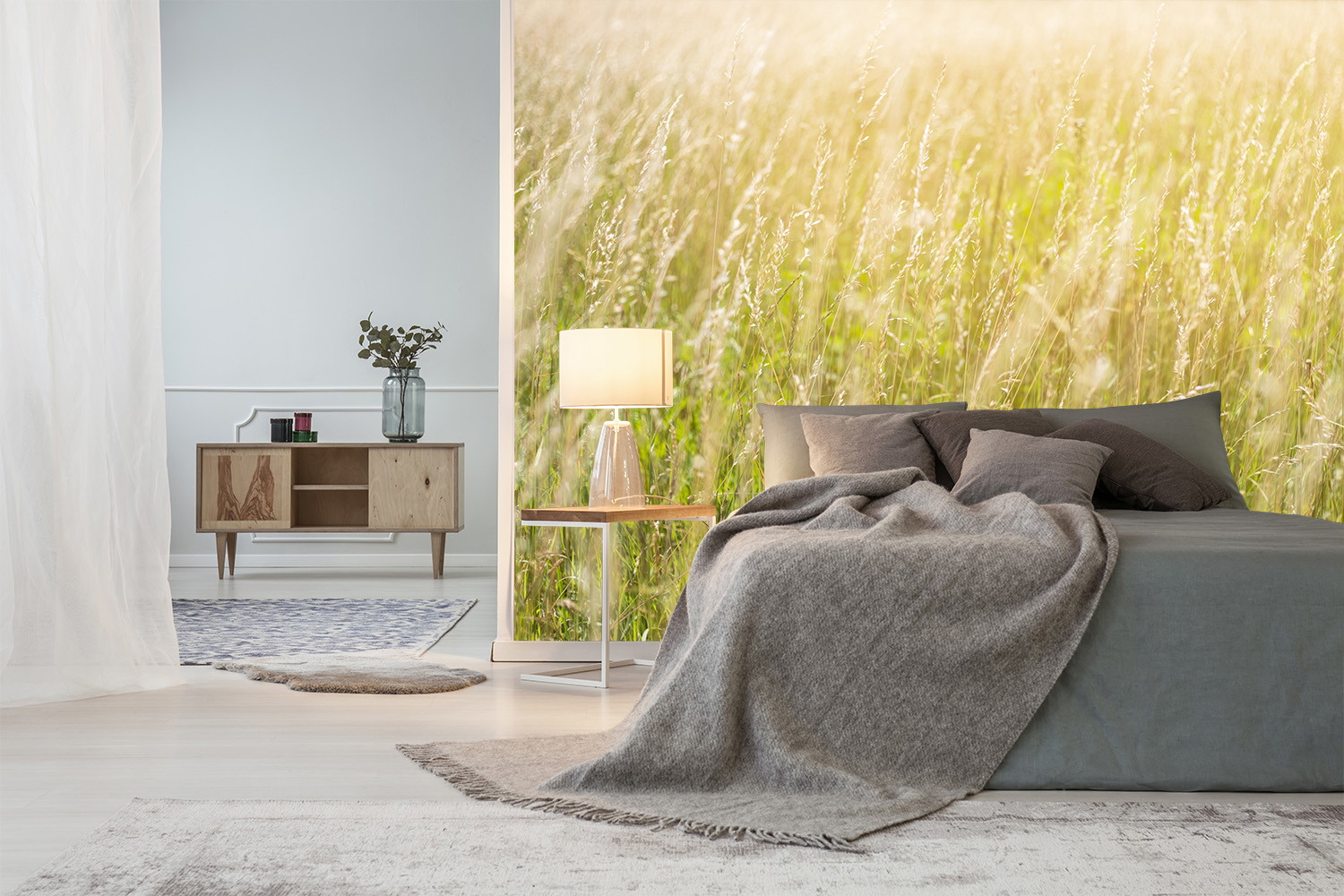 Fotomurale - Camera da letto elegante con un motivo naturalistico sulla parete, un prato verde e rilassante alla luce del sole