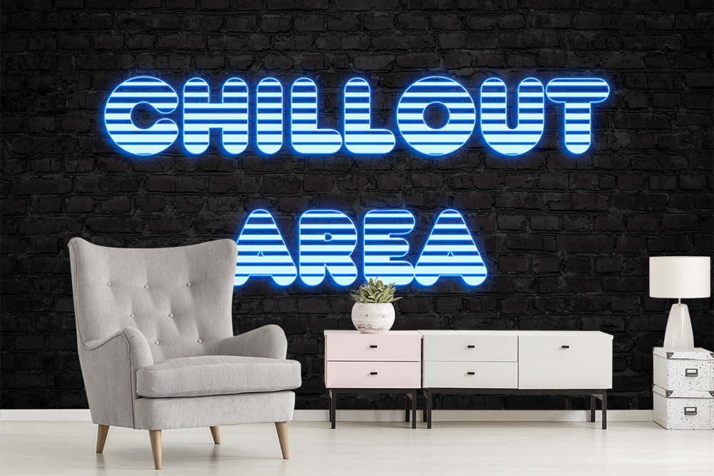 Muurschildering - Chillout ruimte met een grijze fauteuil, een moderne ladekast en blauwe verlichte letters op een bakstenen muur
