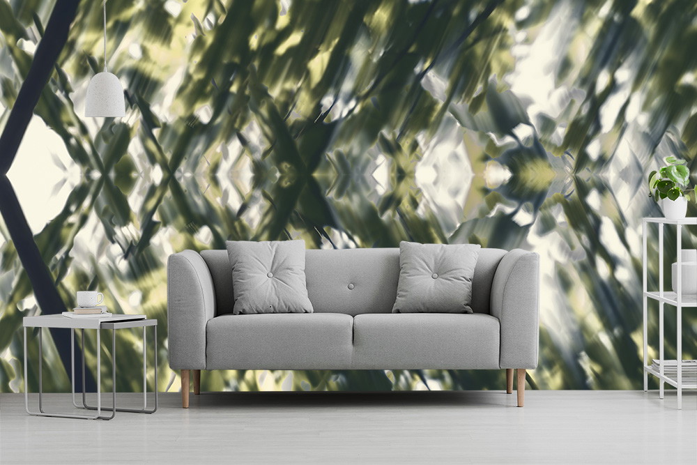 Fotobehang - Een stijlvolle woonkamerinrichting met fotobehang met een abstract bladpatroon en een geometrisch ontwerp, aangevuld met een grijze bank en een bijzettafeltje.