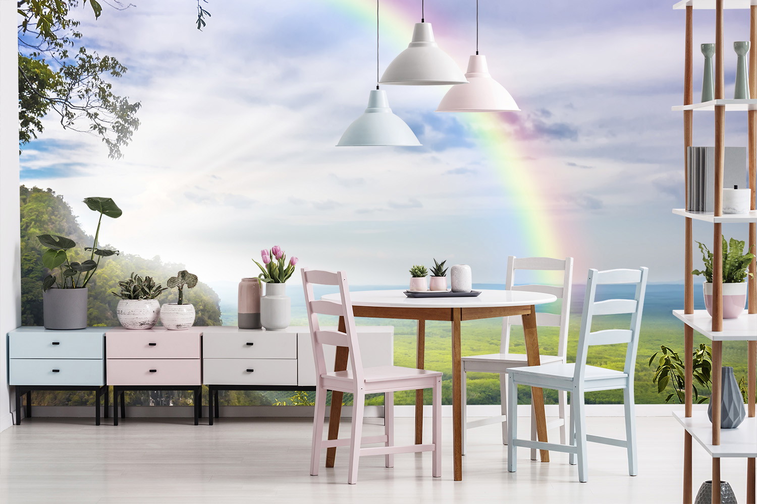 Fototapete - Helles Esszimmer mit Holztisch, Pflanzen und weißem Sideboard vor einer Landschaft mit Regenbogen.