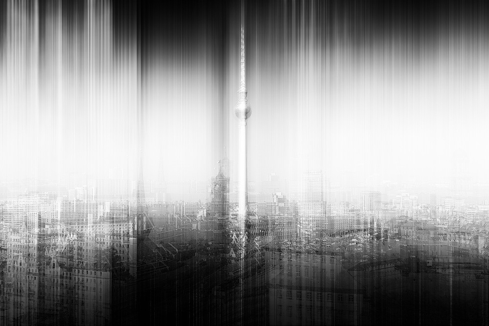 Wall mural - Blurred, abstract city view with a television tower radiating vertical lines, in black and white.