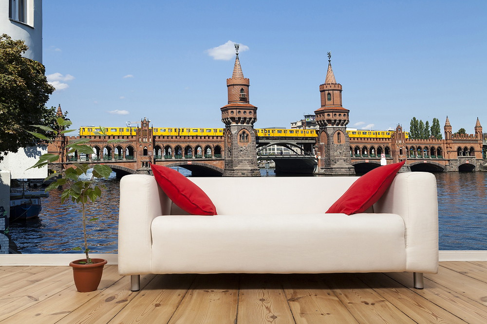 Papier peint photo - Salon élégant avec canapé et vue sur un pont historique avec le passage d'un métro jaune