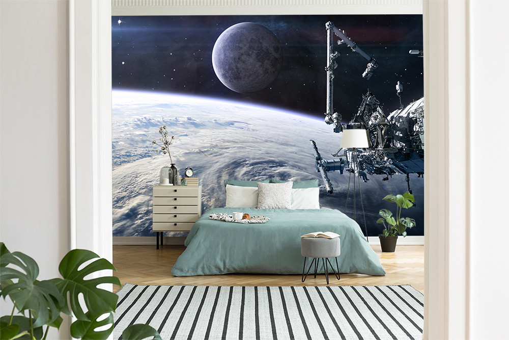 Muurschildering - slaapkamer met een ruimtescène met de aarde, de maan en een ruimtestation