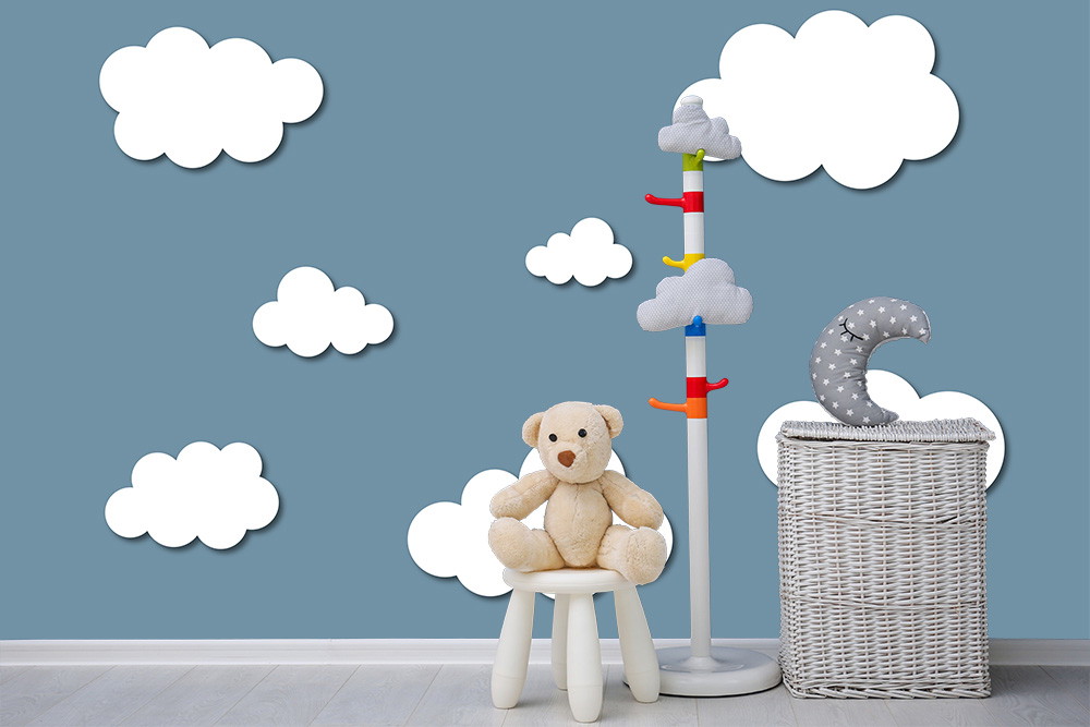 Fototapete - Gemütliches Kinderzimmer mit blauer Wand mit Wolken, Teddy auf Hocker, Wolkenständer und weißem Korb