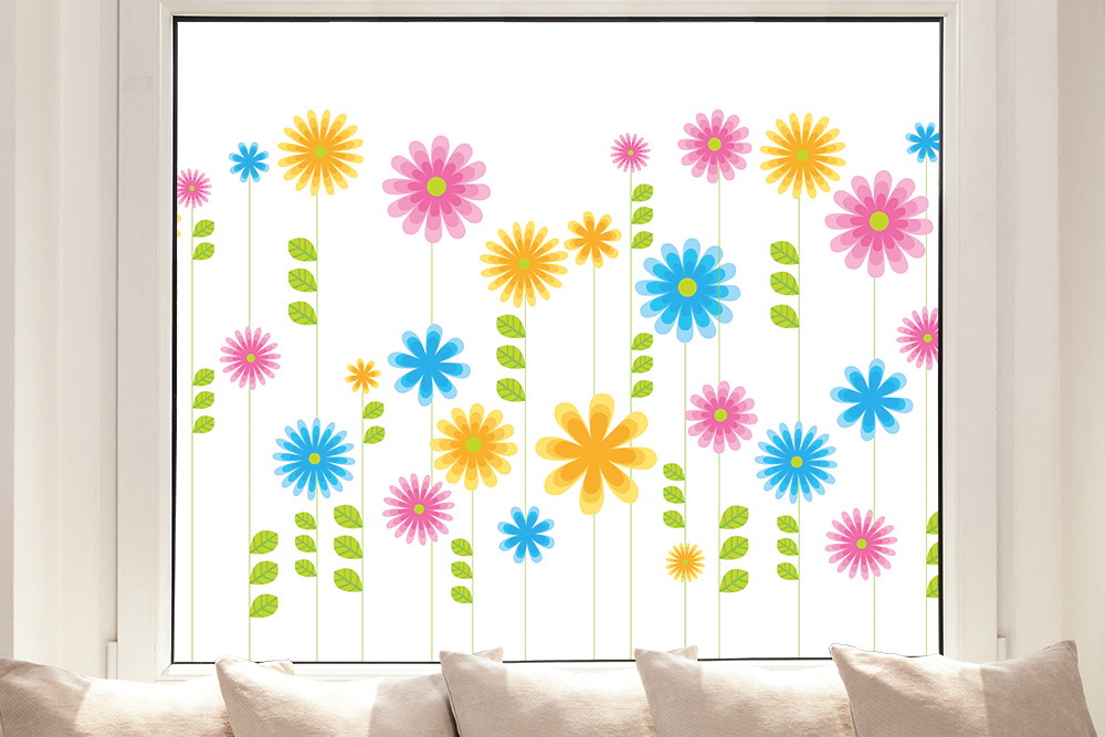 Fenstersticker - Leuchtend bunte Blumenmuster auf einem Fenster mit Kissen im Vordergrund
