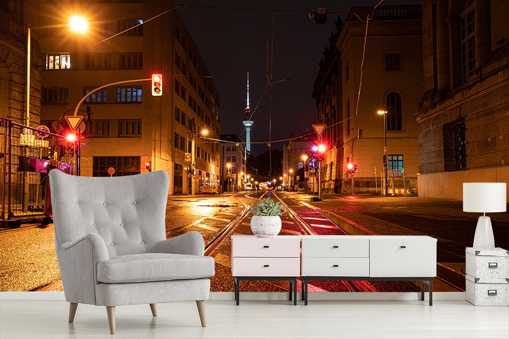 Fototapete - Straßenszene bei Nacht mit leuchtenden Ampeln und Blick auf den Fernsehturm, integriert in ein modernes Wohnzimmerdesign