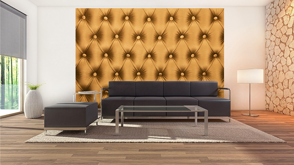 Wall mural - Modern living room with golden, quilted wallpaper behind a black couch and glass table