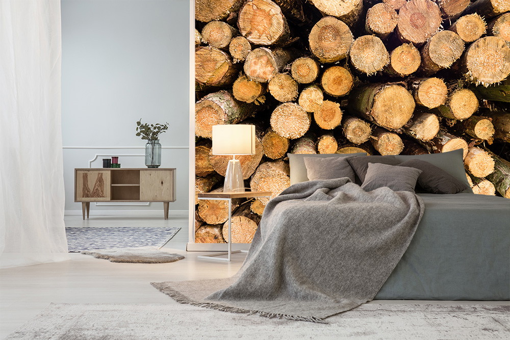 Fotomurale - Camera da letto accogliente con decorazioni moderne e carta da parati in legno con motivi di tronchi d'albero accatastati come richiamo visivo