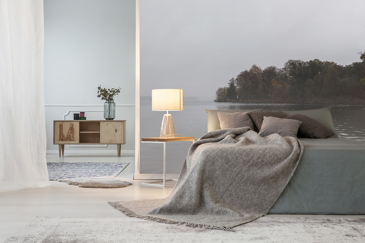 Fototapete - Modernes Schlafzimmer mit Seeansicht, Bett, bequemer Decke und stilvollem Beistelltisch mit Lampe