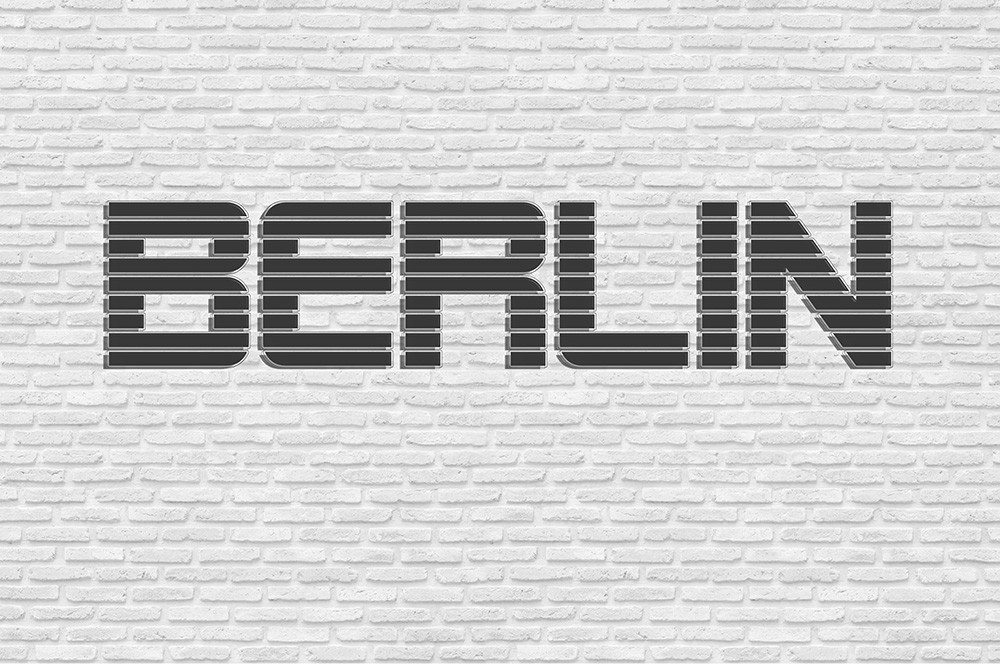 Fototapeta - Czarny napis Berlin w stylu industrialnym na białej ścianie z cegły