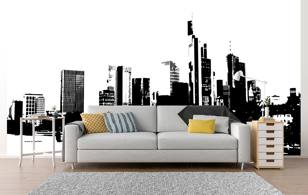 Muurschildering - Zwart-witte skyline van een stad achter een moderne bank met gele en grijze kussens in een stijlvolle woonkamer