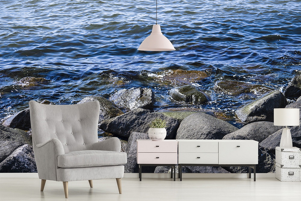 Papier peint photo - salon avec motif de mer, plage de pierres et intérieur moderne