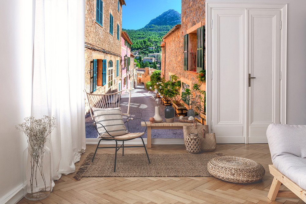 Fototapete - Wohnzimmer mit mediterraner Gassenansicht und Bergen im Hintergrund