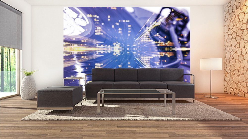 Fototapete - Wohnzimmer mit schwarzem Sofa und gläsernem Tisch vor einer futuristischen Wandtapete mit leuchtenden Lichteffekten in Blau und Gold.