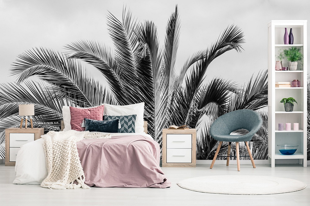 Fotobehang - Slaapkamer met een stijlvol zwart-wit palmenpatroon en elegante meubels