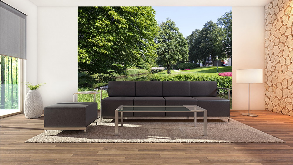 Muurschildering - Woonkamer met zwarte bank en parklandschap op de achtergrond