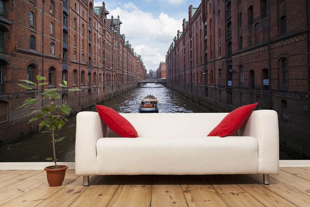 Fototapete - Hamburger Speicherstadt, historische Backsteinhäuser mit Kanal und vorbeifahrendem Boot