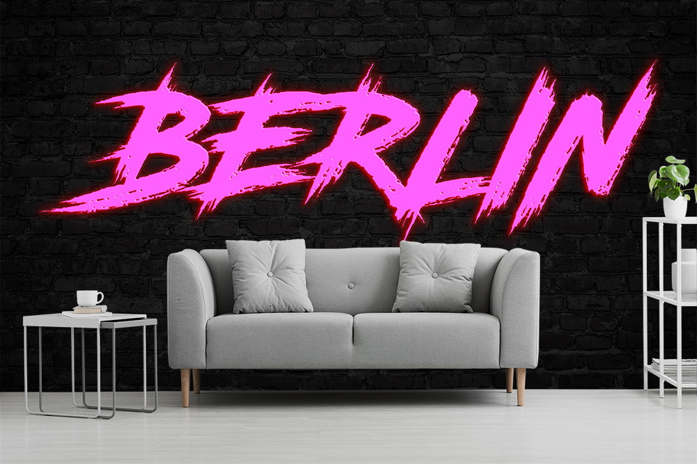 Fototapete - Ein graues Sofa vor einer schwarzen Wand mit dem Wort 'Berlin' in leuchtendem Pink im Graffiti-Stil