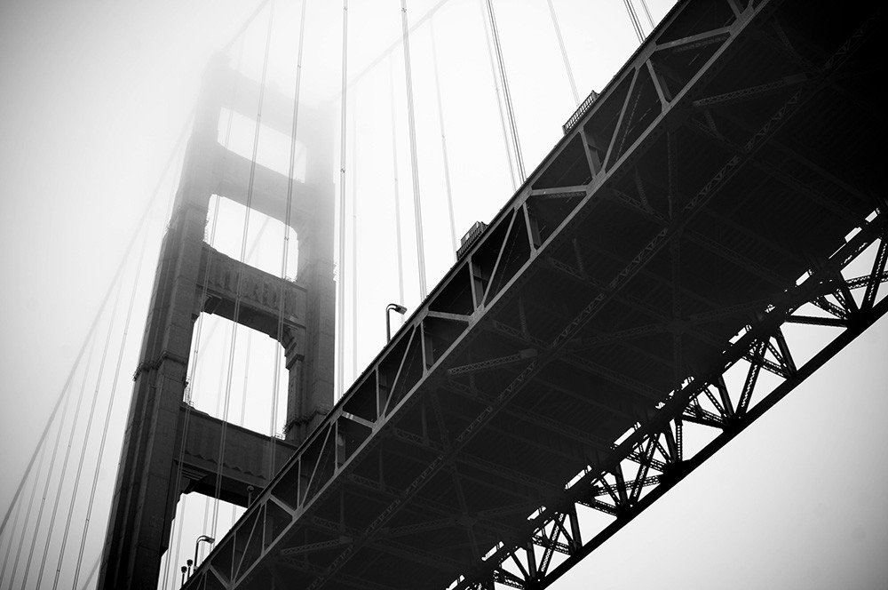 Papier peint photo - photo en noir et blanc d'un grand pont suspendu dans le brouillard d'une perspective inhabituelle