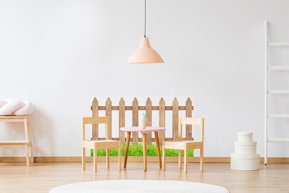 Fototapete - Kinderzimmer mit kleinem Tisch und Stühlen aus Holz, dekorativer Holzzaun im Hintergrund und pastellfarbene Dekorationen