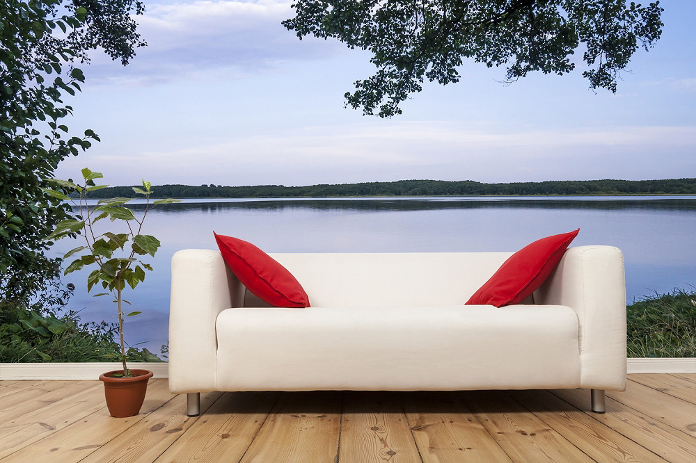 Wall mural - Modern living room with white sofa and red accent cushions in front of a wall mural of a lake