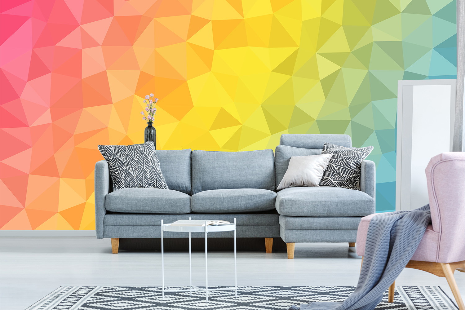 Fototapete - Helles Wohnzimmer mit grauem Sofa, buntem geometrischem Wanddesign und dekorativen Kissen