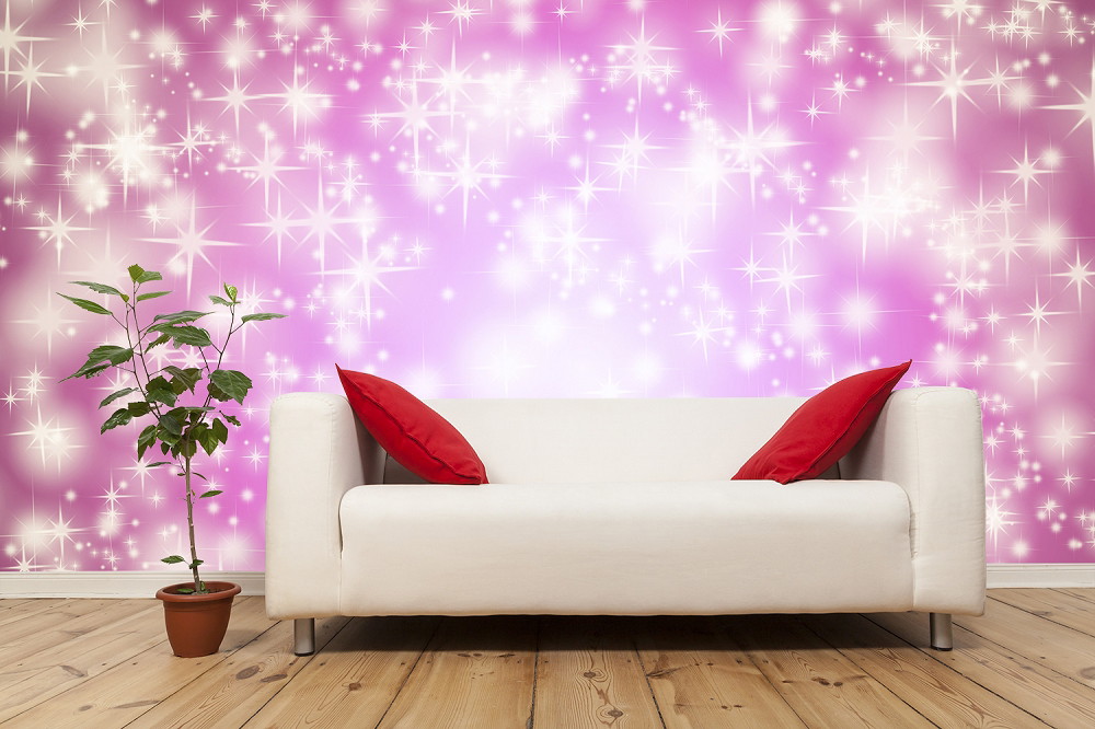 Fototapete - Gemütliche weiße Couch mit roten Kissen vor einer rosa Wand mit Sterneneffekt und einer Topfpflanze