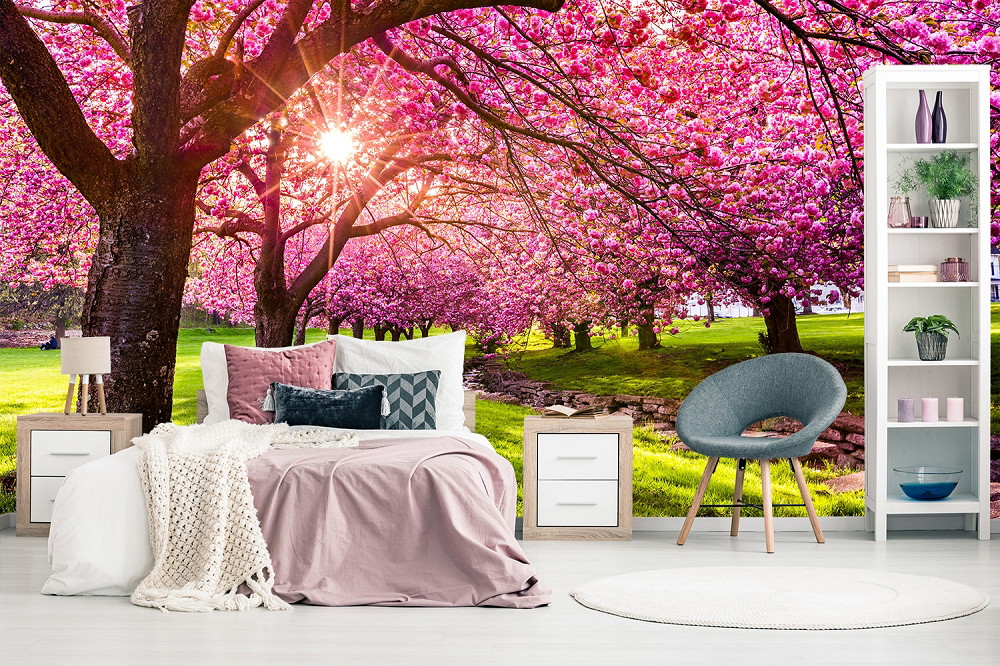 Muurschildering - Slaapkamer met bed, stoelen en kersenbloesembehang met een zonnige lentetuin