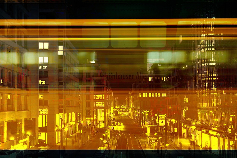 Wall mural - Night landscape of a city with illuminated buildings and a moving train in the foreground