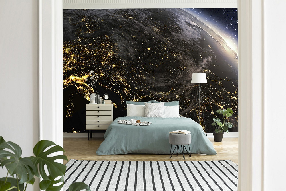 Fototapete - Schlafzimmer mit einer Wand, die eine beeindruckende Weltraumansicht der Erde bei Nacht zeigt, mit leuchtenden Städten und Landschaften