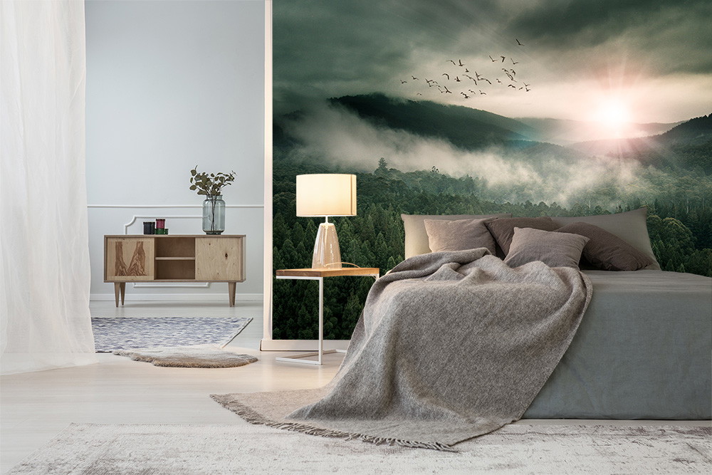 Fototapete - Gemütliches Schlafzimmer mit Waldlandschaft, Sonnenuntergang und fliegenden Vögeln im Hintergrund