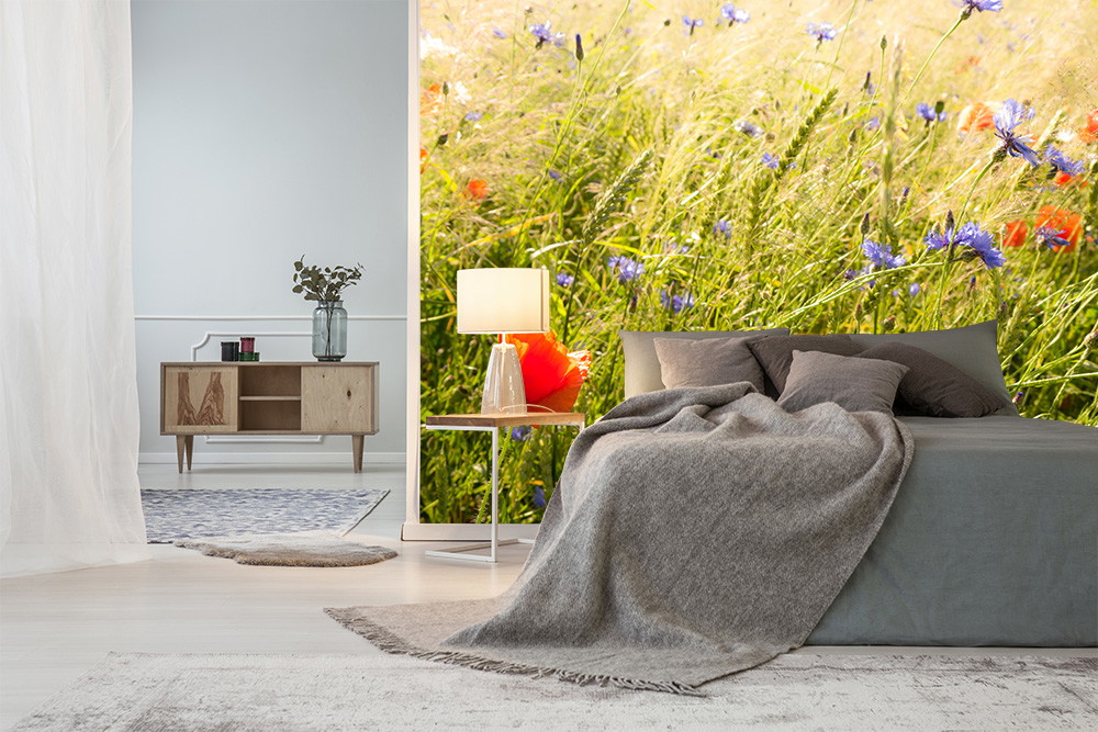 Fototapete - Schlafzimmer mit Blumenmotiv-Tapete, grauem Bett und Holzmöbeln