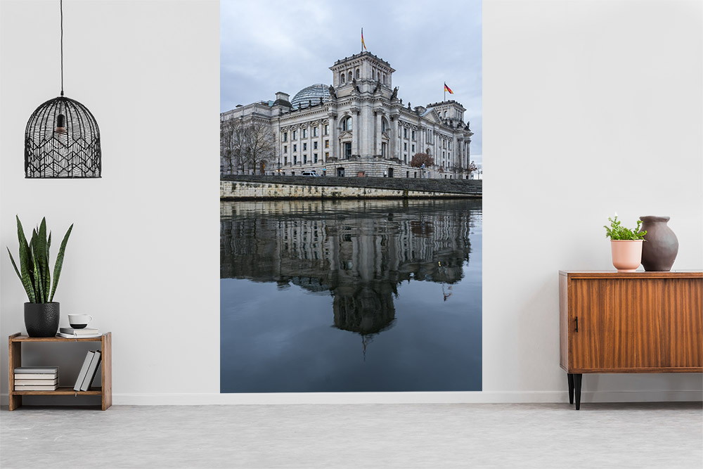 Fototapete - Ein imposantes historisches Gebäude spiegelt sich im Wasser wider, während es in eine moderne Wohnzimmereinrichtung integriert ist.