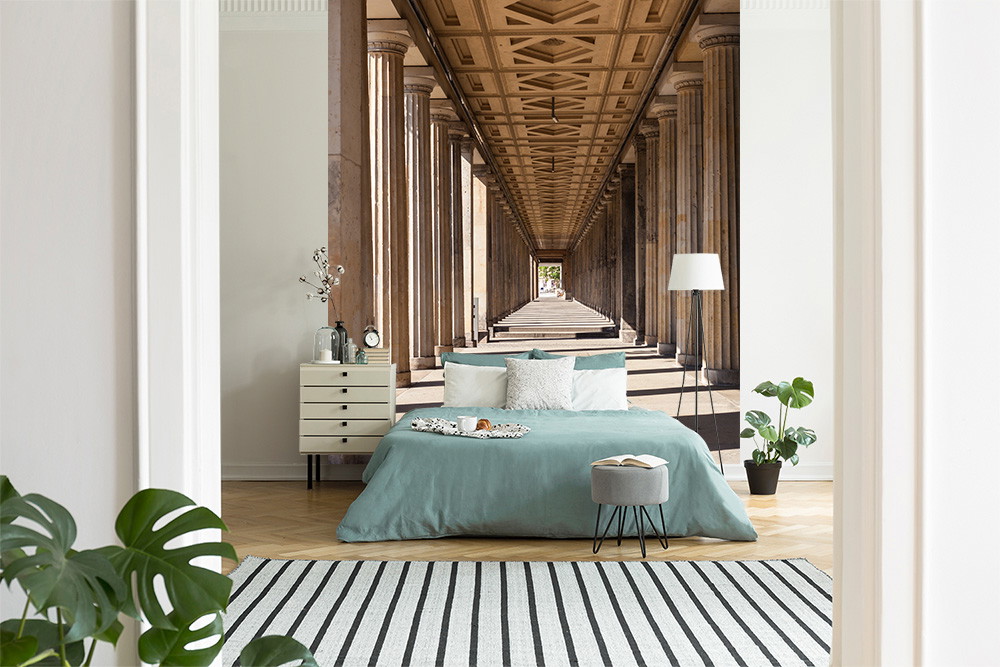 Muurschildering - Slaapkamer met houten vloer, turquoise beddengoed en een prachtig portiekbehang op de achtergrond
