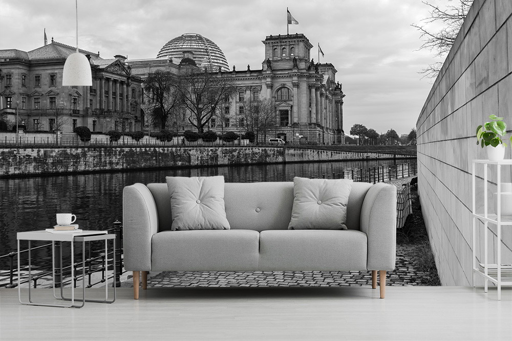 Fototapeta - Sofa przed czarno-białym obrazem rzeki z budynkiem architektonicznym w tle