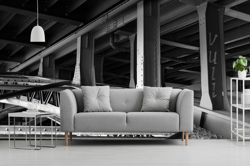 Fototapete - Stilvolle Wanddekoration mit Brückenstruktur in Schwarz-Weiß und grauem Sofa im Vordergrund