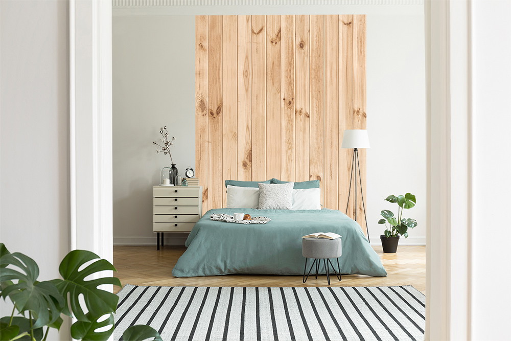 Fototapete - Schlafzimmer mit einer natürlichen Holzpaneel-Akzentwand, grüner Bettwäsche, moderner Einrichtung und Pflanzen im skandinavischen Stil