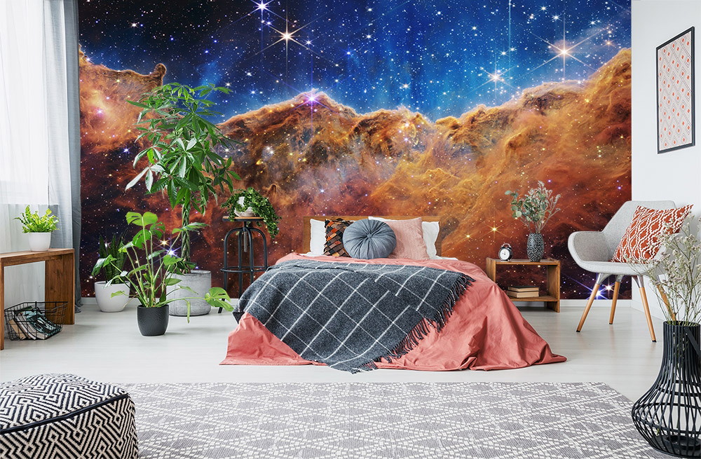 Fotobehang - Slaapkamer met een indrukwekkend ruimtelandschap, met sterren en kosmische nevels, als wanddecoratie achter een gezellig bed