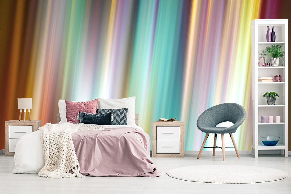 Fotomurale - Camera da letto con Fotomurale colorato e a righe, letto accogliente con cuscini, tavolini e una poltrona