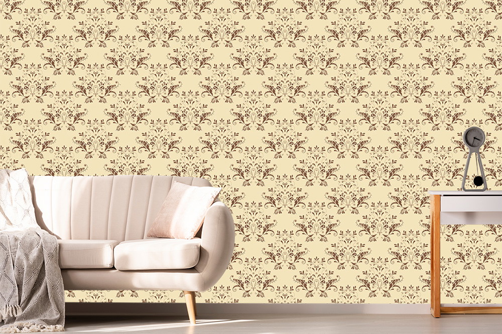 Papier peint photo - mur beige avec un motif floral classique, à côté un canapé crème et une étagère en bois avec une horloge