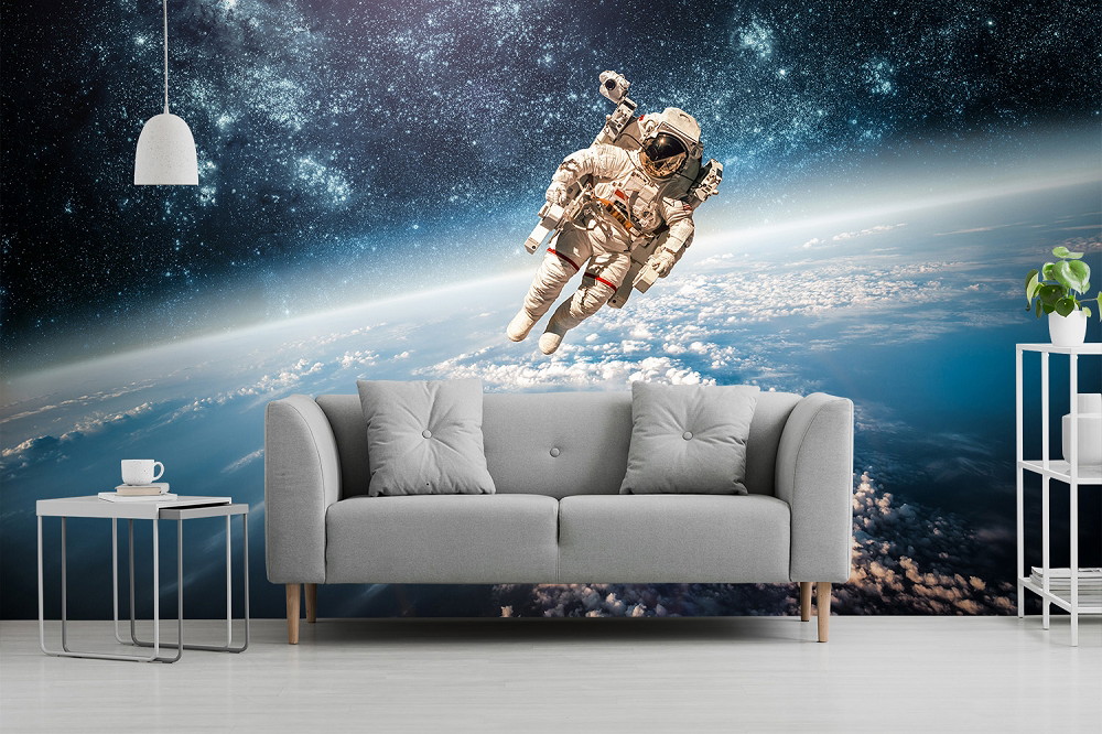 Papier peint photo - pièce avec un motif d'astronaute dans l'espace au-dessus de la terre avec un ciel étoilé