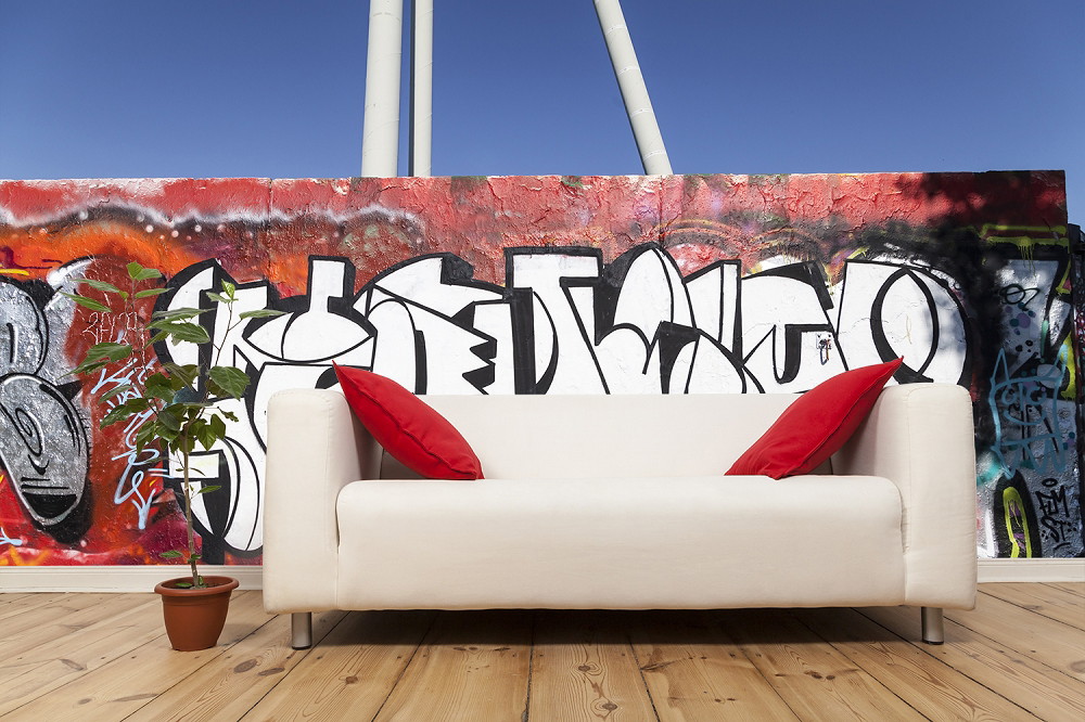 Wall mural - White sofa in front of graffiti wall with red cushions and potted plant