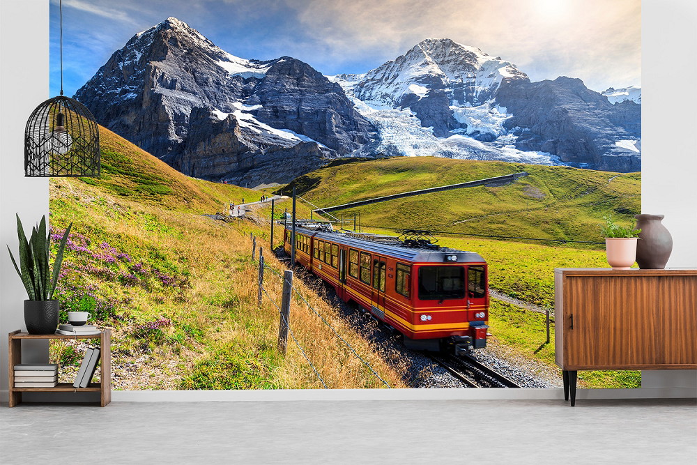 Fototapete - Panorama eines roten Zuges, der durch eine malerische Alpenlandschaft mit majestätischen, schneebedeckten Bergen fährt
