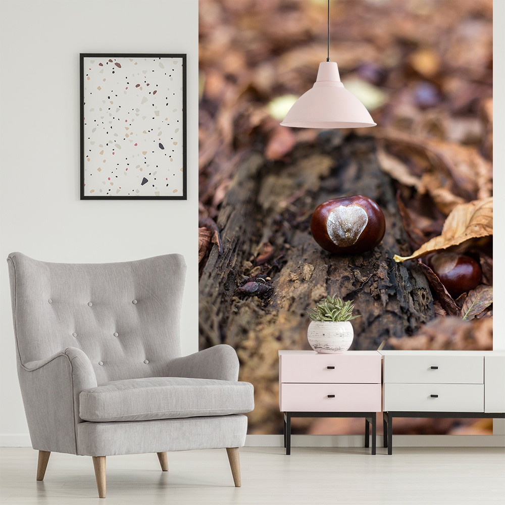 Fotomurale - Castagne e foglie autunnali su un tronco d'albero nel soggiorno con poltrona grigia e lampada a sospensione