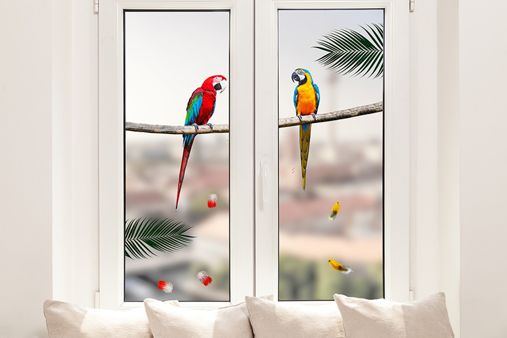 Fenstersticker - Zwei farbenfrohe Papageien sitzen auf einem Ast vor einem Fenster mit verschwommenem Hintergrund.