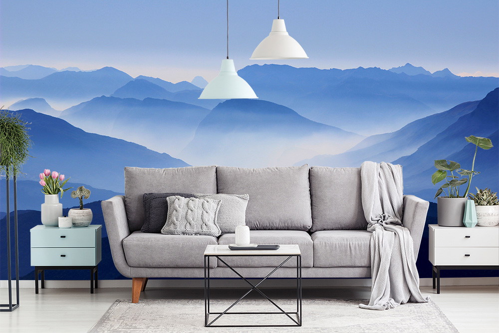 Fototapete - Wohnzimmer mit grauem Sofa, modernen Möbeln und einer Fototapete von blauen Bergen