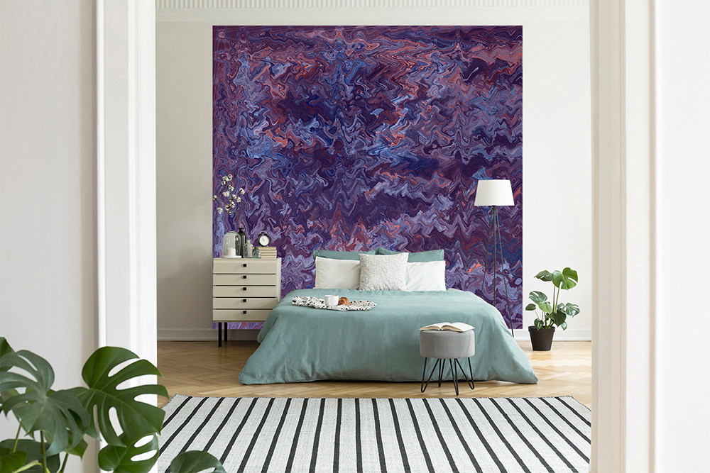 Wallpaper mural - bedroom with large wall covered in abstract purple pattern wallpaper with a bed with a green duvet and decorative plants in the background
