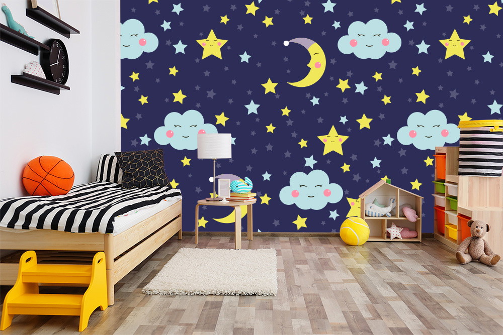 Fotobehang - Kinderkamer met een bed, speelgoed en blauw behang met een patroon van wolken, manen en sterren